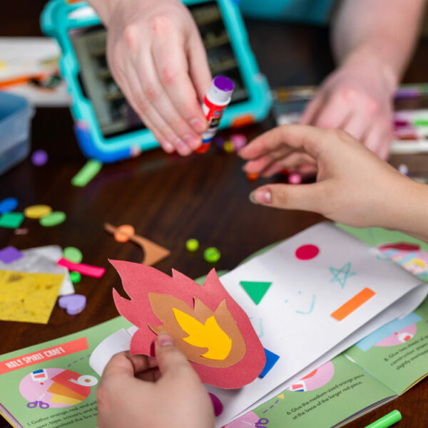 A father helping his daughter make the holy spirit craft.