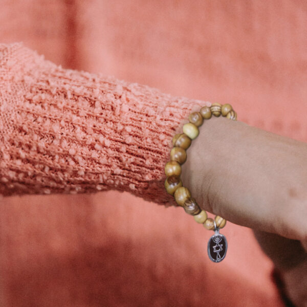 Woman wearing One New Man Bracelet made of olive wood